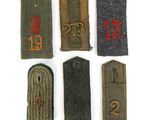 six military badges with numbers and numbers on them on a white surface