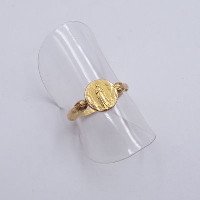 Gros plan sur une bague en or ornée d'une pièce de monnaie