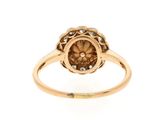 a close up of a gold ring with a flower design