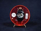 un petit objet rouge contenant une montre noire