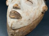 a close up of a clay mask on a table