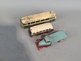 three toy cars and a bus on a white surface