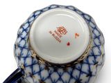 an image of a blue and white coffee cup with a gold rim