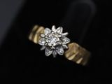 a close up of a gold and diamond ring on a black surface