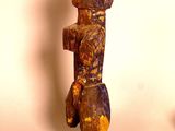 a wooden sculpture of a person standing on a base