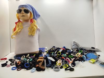 une poupée assise devant une pile de ciseaux