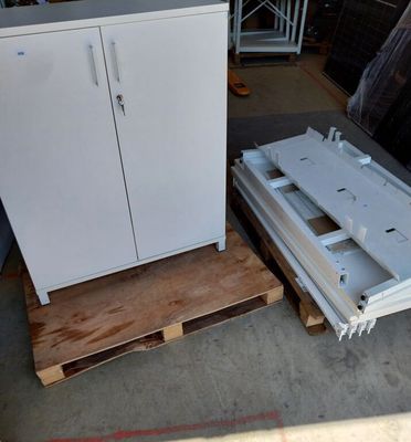 une armoire blanche posée sur une palette, à côté d'une palette en bois
