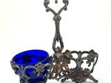 two blue glass bowls and a silver plate on a white background