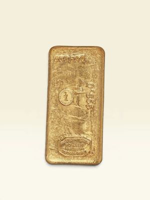 une barre d'or posée sur une surface blanche