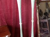 two tall vases sitting next to a mirror in a room