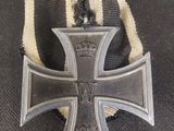 une croix de fer entourée d'un ruban et surmontée d'une couronne