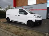 la camionnette blanche est garée devant un bâtiment dans un parking