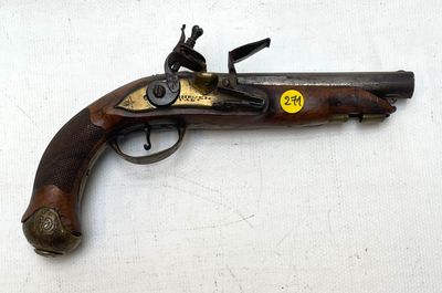 un vieux pistolet posé sur une surface blanche