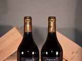 two bottles of wine sitting next to each other on a table