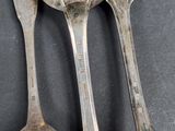 two spoons and a spoon on a black surface