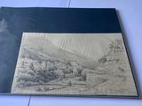une vieille photo représentant un dessin représentant un paysage de montagne posé sur une table
