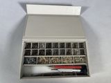 a metal box filled with assorted metal items on a white surface