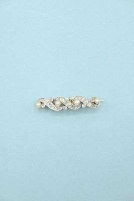 a close up of a silver ring with pearls on a blue surface