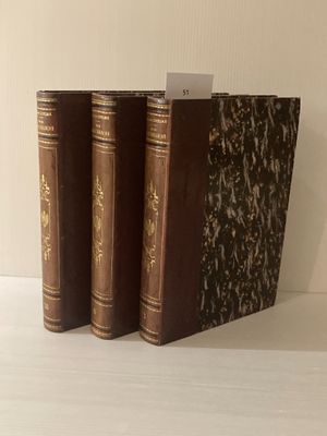 trois livres posés sur une table blanche