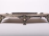 an antique silver plate with a decorative design on it
