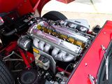 a red car with an engine in the trunk of it