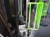 a machine that is sitting in a garage with a green handle