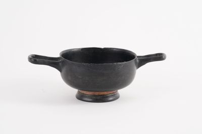 an image of a small black bowl with handles on a white surface
