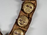 a gold necklace with skulls on it on a white surface