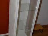 une armoire blanche avec une porte vitrée, dans un coin de la pièce