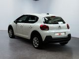 the back of a white car is parked in a room