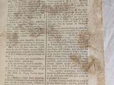 an old book sitting on top of a white sheet of paper
