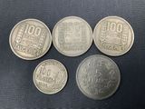 four different types of coins are shown on a black surface
