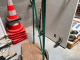 a hand truck with a wooden board on it in a garage