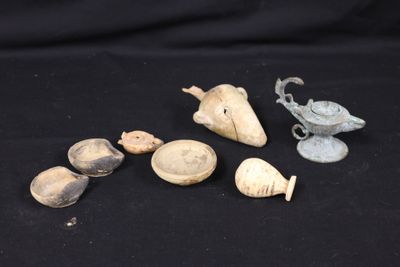 several pieces of pottery sitting on top of a black surface