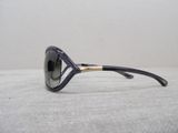 black and gold sunglasses on a white surface with a white wall in the background