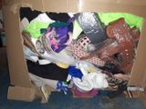 a cardboard box full of clothes and shoes on the floor