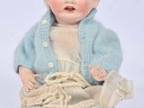 a baby doll that is sitting on the ground