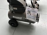 a small air compressor sitting on a cart in a warehouse