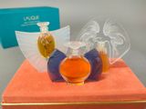 three bottles of perfume sitting on top of an orange box
