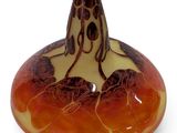 a brown and orange vase sitting on top of a white table