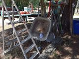 a wheelbarrow leaning against a tree in a yard
