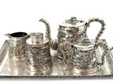 a silver tray with a silver tea set on it