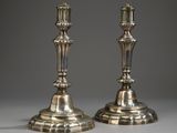 une paire de bougeoirs en argent sur fond gris
