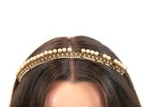 une femme qui porte un bandeau orné de perles