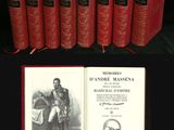 Six livres rouges sont alignés sur une table noire