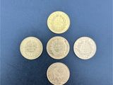 cinq pièces de monnaie britanniques différentes sont disposées sur un fond bleu