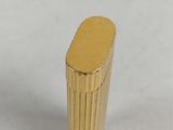 a close up of a gold metal object on a white surface
