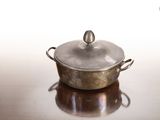 une casserole en argent avec un couvercle, posée sur une table