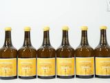 six bouteilles de bière sont alignées sur une surface blanche