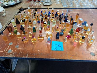 many bottles of perfume on a table with a price tag
